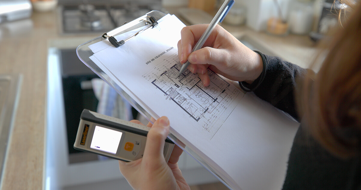 mains-plans-immeuble-crayon-etude-telemetre